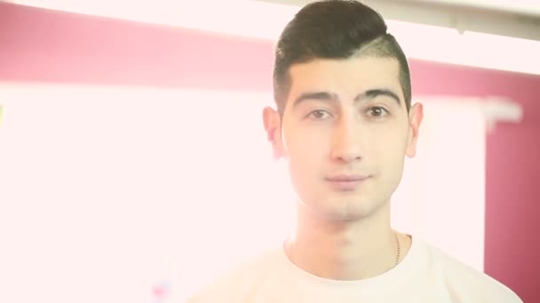 Handsome young man looking into the camera and winks closeup. — Stock Video