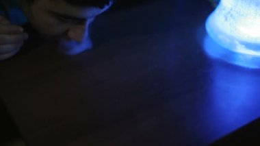 Genç adam bir hile ile bir duman yapmak istiyor.