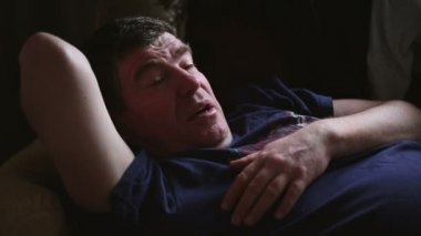 Ortalama yıllık adam kanepede yatıyor.