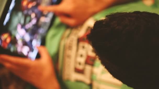 Молодой человек играет в игру на планшете . — стоковое видео