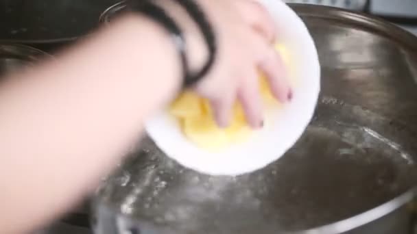Kuchař přidává nakrájené brambory na pánvi horké vody. — Stock video