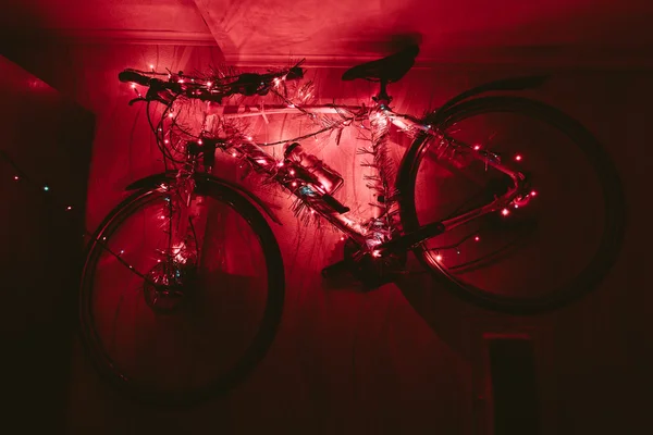 Bicycle on a wall decoration of the christmas lamp garland. — Stock Photo, Image