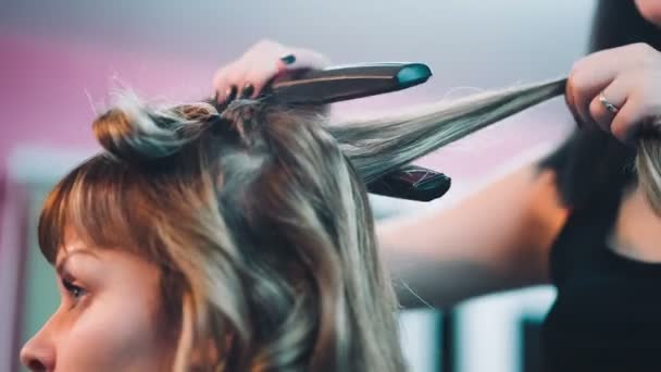 Salon fryzjerski prostuje włosy klienta. — Wideo stockowe