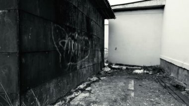 Paslı garajlar ve yeni beyaz bina arasında boş alanı.