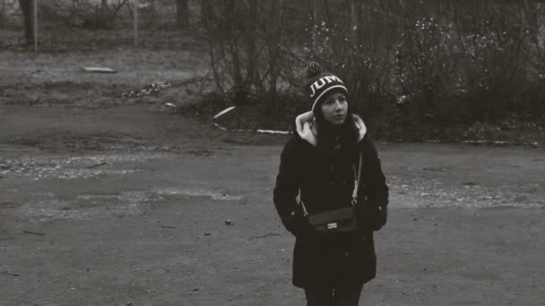 Ensam tjej stående på gatan i kavaj och hatt. — Stockvideo