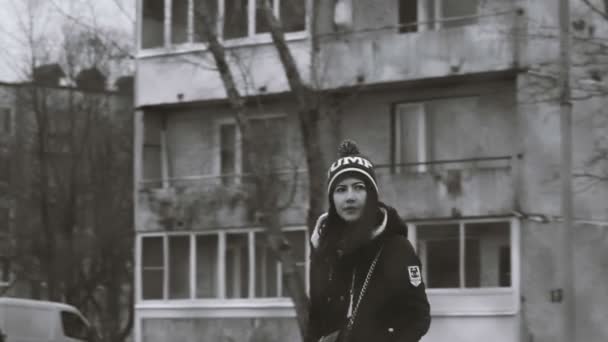 Lonely girl walking along the road behind a fence camera switches focus. — Stock Video