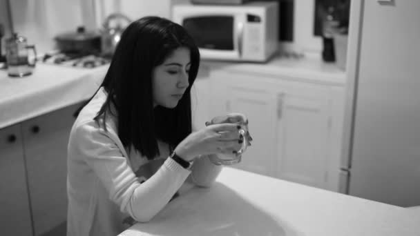 Mooi meisje het drinken van thee in de keuken. — Stockvideo