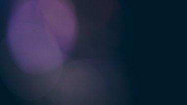 Siyah bir arka plan üzerinde hareketli renkli bokeh ışıklar.