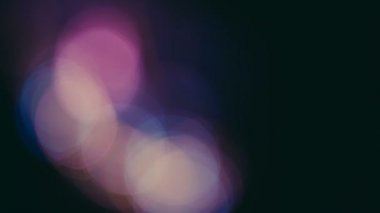 Siyah bir arka plan üzerinde hareketli renkli bokeh ışıklar.