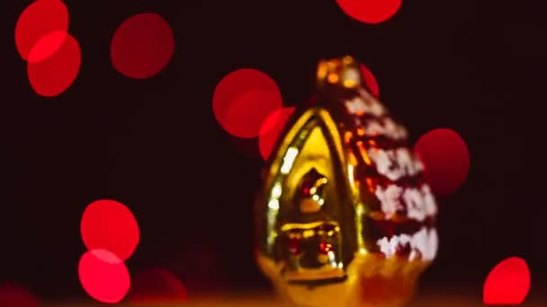 Gold-Weihnachtsspielzeug dreht sich auf Bokeh-Hintergrund um die eigene Achse. — Stockvideo