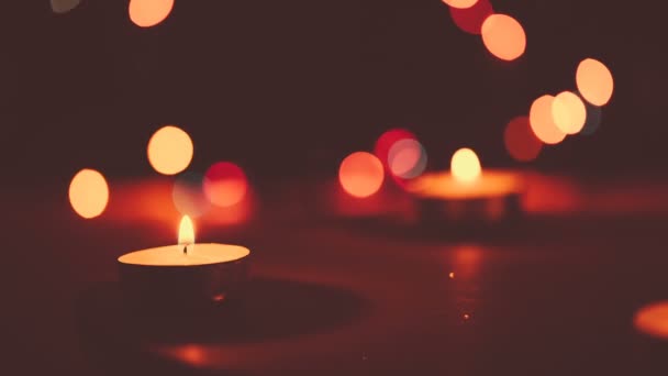 Two candles burning on a bokeh background.