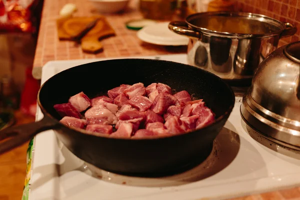 A húst vágjuk kockákra serpenyőben sült. — Stock Fotó