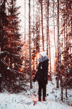 Güzel kız beyaz bir şapka ve bir arka plan bir kış ormanın bir ceket.