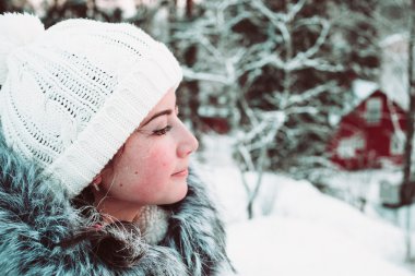 Beyaz bir kap ve bir arka plan bir kış ormanın bir ceket genç kadın.