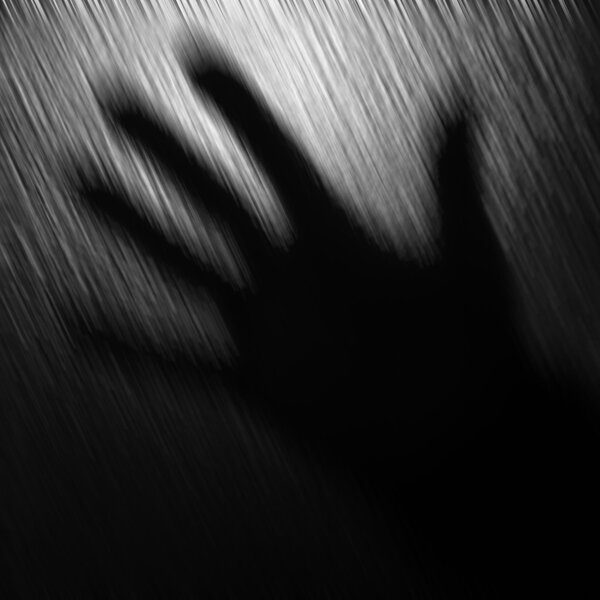 Blurred black and white background with one hand.