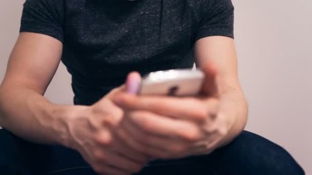 Молодой человек пользуется своим смартфоном . — стоковое видео