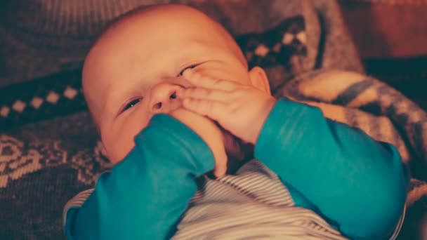 Bébé garçon jouer avec les mains et les met dans une bouche mère interdit puis l'embrasse sur la tête . — Video