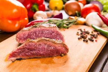 Sliced Rare Roast Beef on Wooden Cutting Board