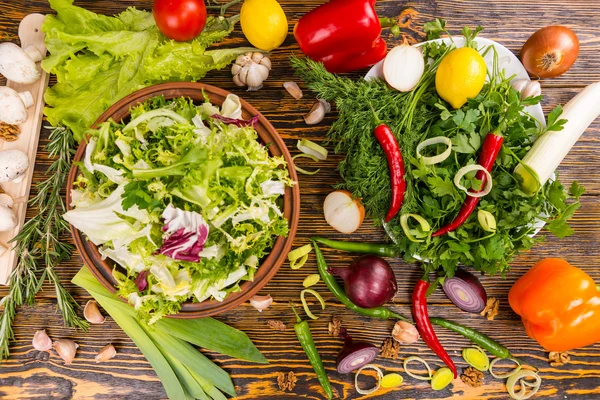 Sobreabundancia de ingredientes de ensalada en la mesa — Foto de Stock