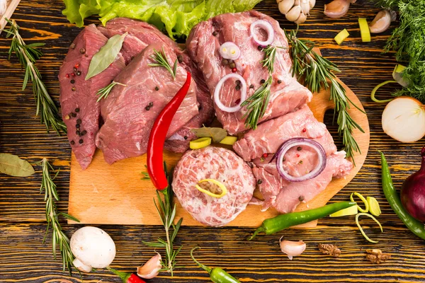 Verschillende soorten rood vlees op snijplank — Stockfoto