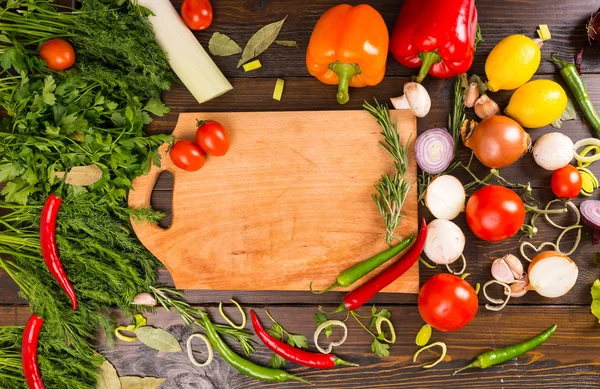 Tabla de cortar vacía rodeada de verduras — Foto de Stock