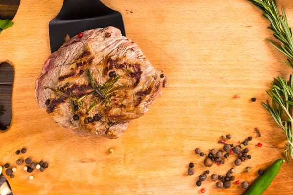 Cooked beef patty in spatula with herbs — Stock Photo, Image