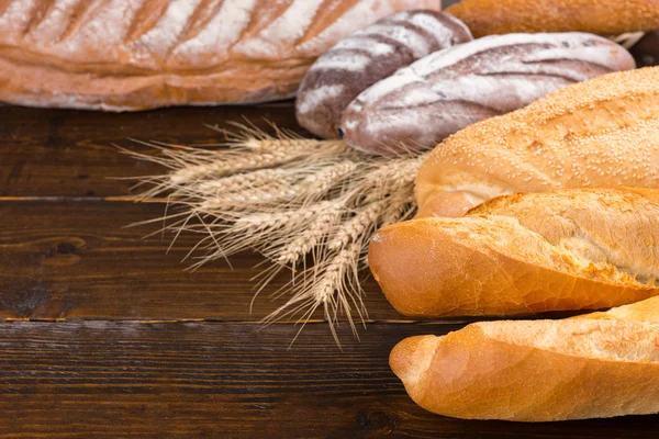 Листья хлеба с пшеничными стеблями на столе — стоковое фото