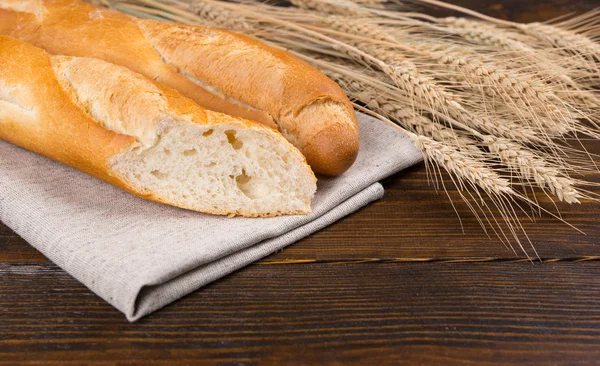 Baguete francesa fresca fatiada com trigo — Fotografia de Stock