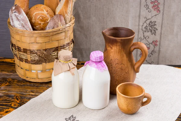 Garrafas de leite com pão na cesta — Fotografia de Stock