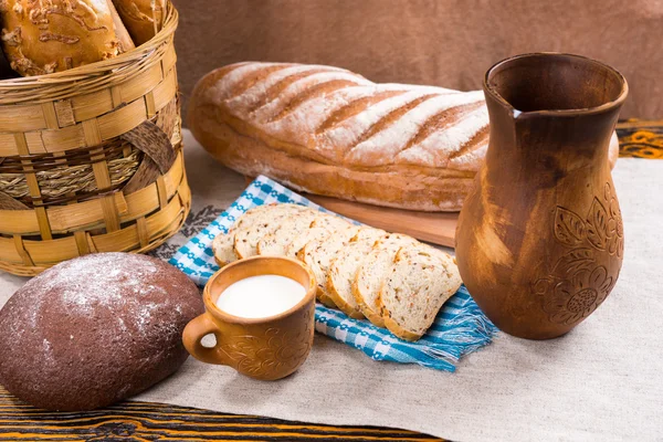 Fából készült kancsó, a tej és friss kenyérrel tábla — Stock Fotó
