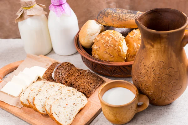 Разнообразный нарезанный хлеб, сыр и молоко на обед — стоковое фото