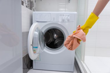 Havlu çamaşır makinesi önünde tutan el