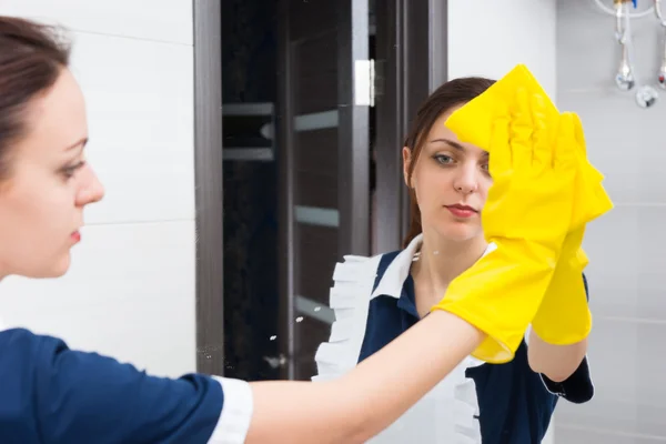 Hotel maid cleaning bathroom mirror — Stock Photo, Image