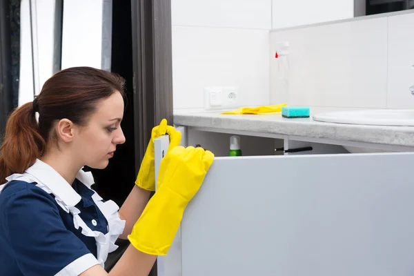 Close up on domestic worker opening sink cabinet — Stock Photo, Image