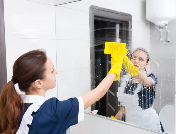 Bathroom mirror being wiped down by maid — Stock Photo, Image