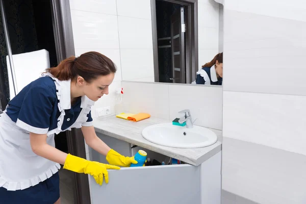 Meid waarbij schoonmaak items in gootsteen worden opgehaald — Stockfoto