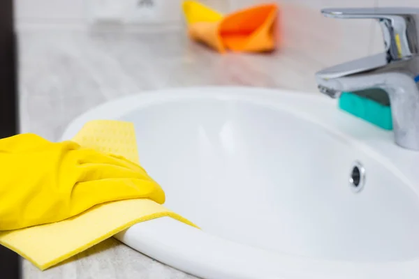 Gloved hand cleaning sink edge — Stock Photo, Image