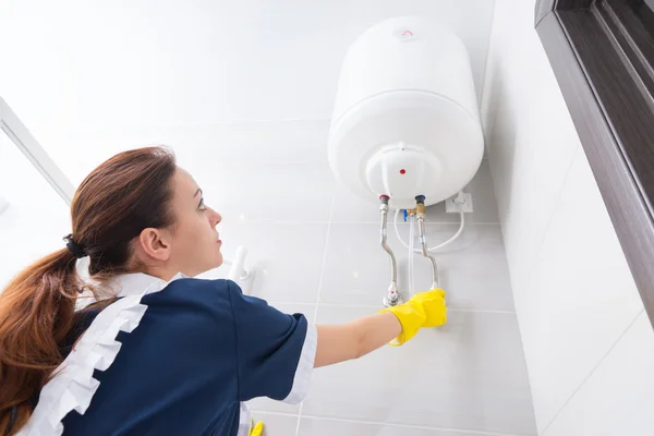 Maid testing ceiling mounted water tank — Stock Photo, Image