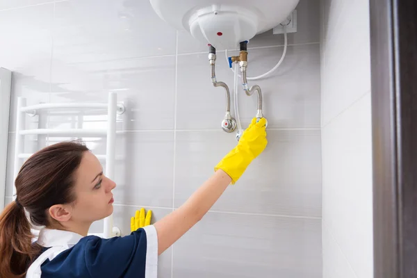 Maid checking water tank — Stock Photo, Image