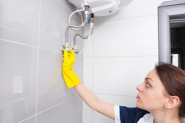 Housekeeper adjusting water tank valves — Stock Photo, Image