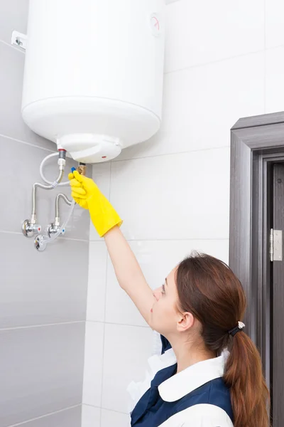 Hotel maid working with water tank valves — Stock Photo, Image