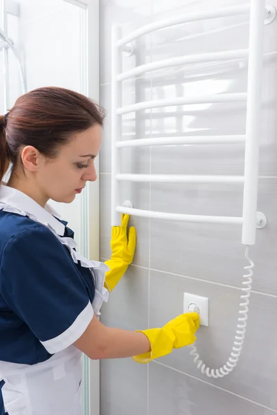 Woman plugging in heated towel rack — Stock Photo, Image