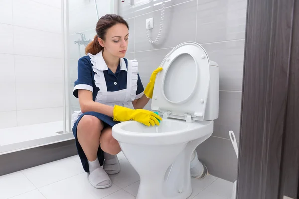 Domestic worker cleaning toilet edge — Stock Photo, Image