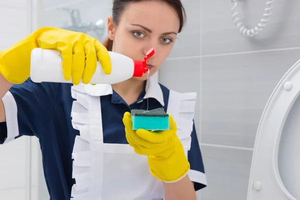 Housekeeper pouring detergent onto a sponge — Stock Photo, Image