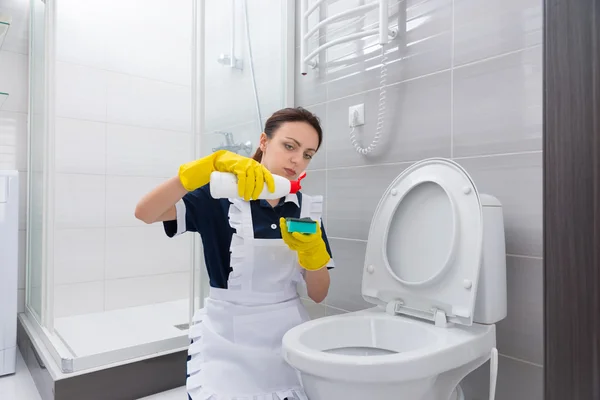 Maid putting cleaner on sponge above toilet — Stock Photo, Image