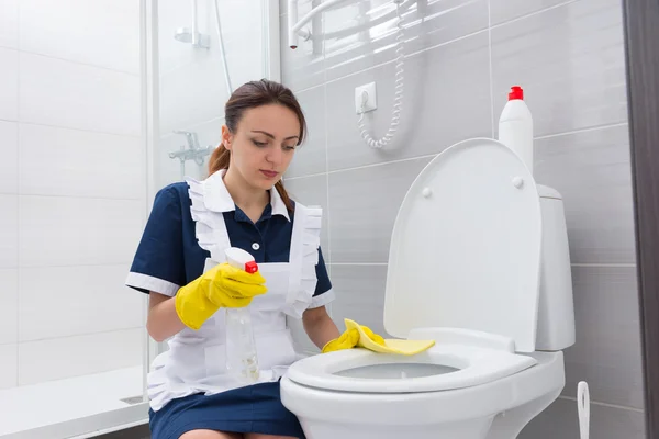 Serious maid cleaning toilet seat — Stock Photo, Image