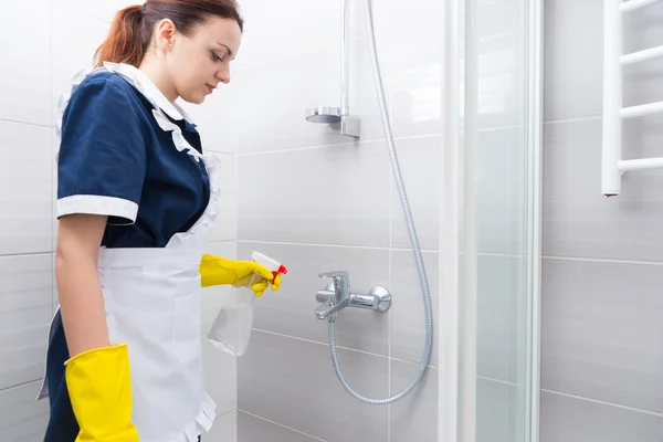 Haushälterin oder Dienstmädchen putzt eine weiße Dusche — Stockfoto