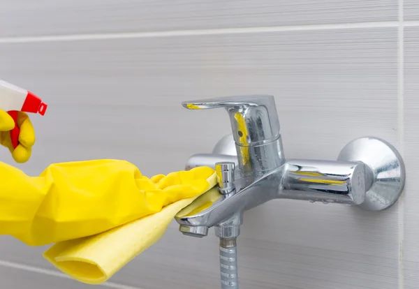 Dona de casa limpar a torneira no chuveiro — Fotografia de Stock