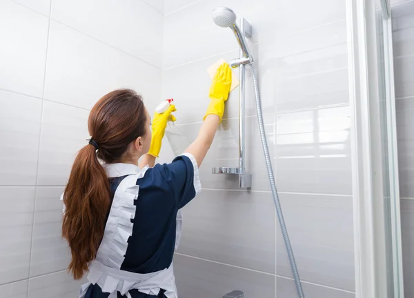 Housekeeper cleaning the shower head — Stock Photo, Image