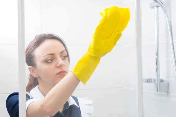 Joven mujer esponjando un cubículo de ducha — Foto de Stock